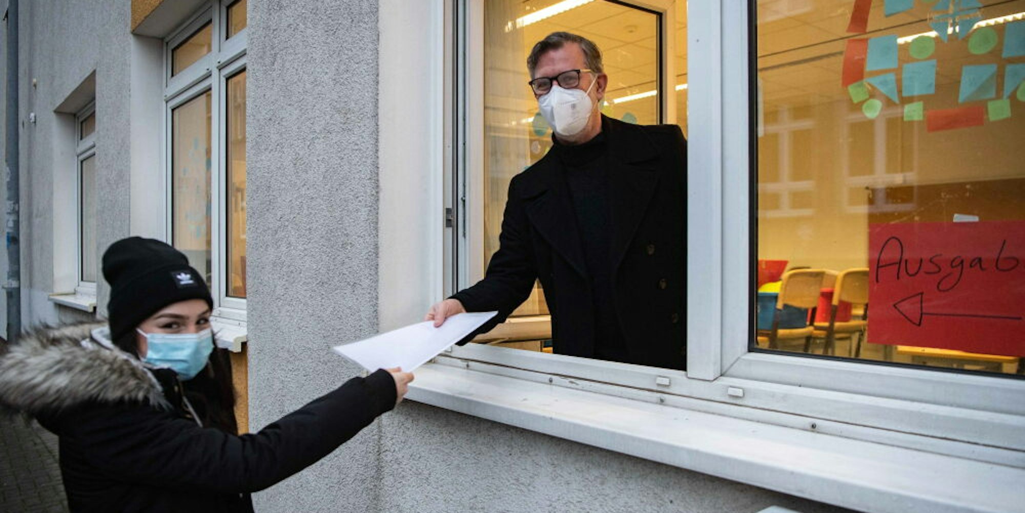 So ist es geplant: Euskirchens Gesamtschulleiter Thomas Müller überreicht einer Schülerin das Zeugnis durchs Fenster – mit Abstand und Mundschutz selbstverständlich.