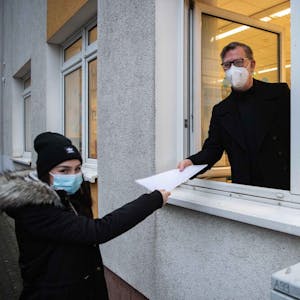So ist es geplant: Euskirchens Gesamtschulleiter Thomas Müller überreicht einer Schülerin das Zeugnis durchs Fenster – mit Abstand und Mundschutz selbstverständlich.