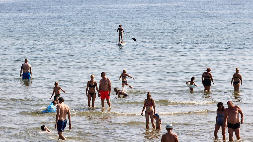 Menschen baden in der Ostsee.