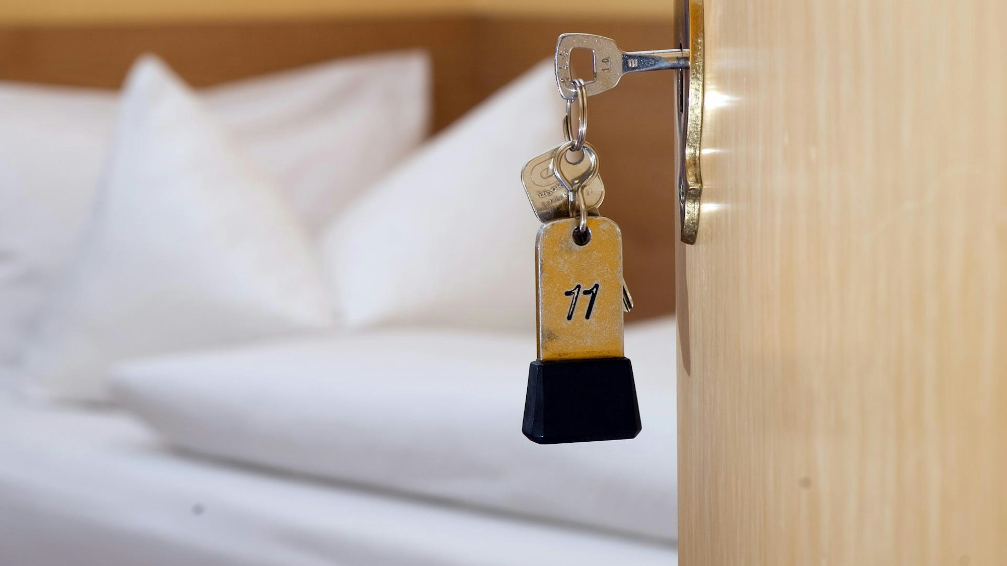 Das undatierte Symbolfoto zeigt einen Schlüssel, der in der Tür eines Hotelzimmers steckt.