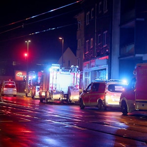 Fahrzeuge von Feuerwehr und Rettungsdienst stehen nachts am Straßenrand.
