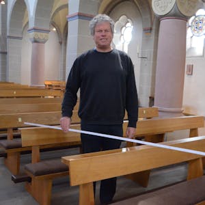 Den korrekten Abstand zwischen den Sitzplätzen hat der Hennefer Pfarrer Christoph Jansen mit dem Zollstock ermittelt.