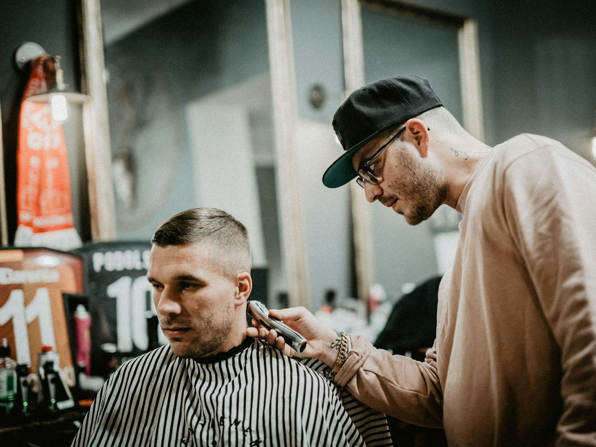 Lukas Podolski lässt sich die Haare schneiden.