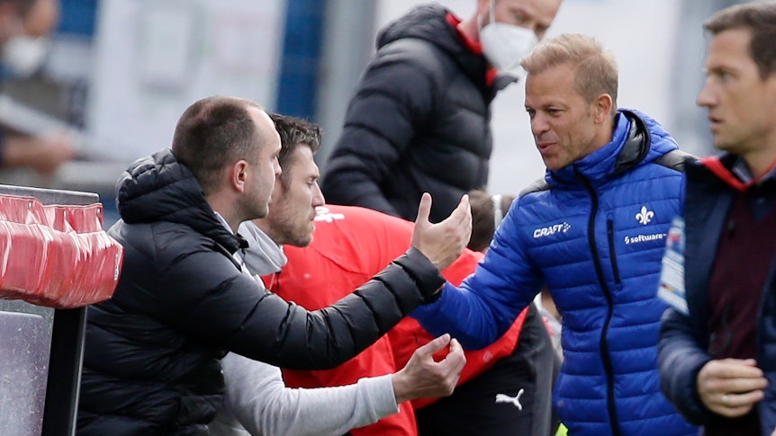 Markus Anfang und Ole Werner, Trainer von Zweitligisten SV Darmstadt und Holstein Kiel, begrüßen einander vor dem Spiel.