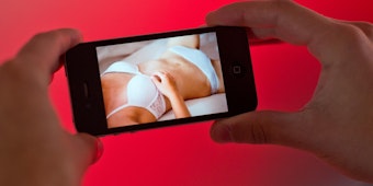 Jemand schaut einen Porno auf einem Smartphone