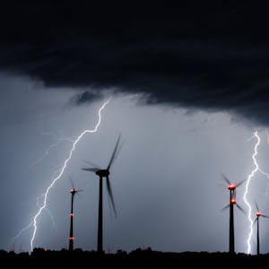 Blitze schlagen neben Windrädern ein (Symbolbild).