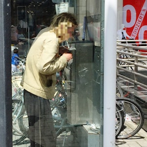 Ein Mann konsumiert Heroin in einer Telefonzelle.
