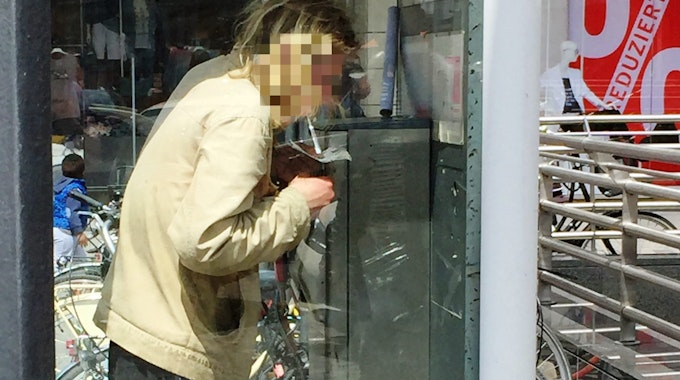 Ein Mann konsumiert Heroin in einer Telefonzelle.