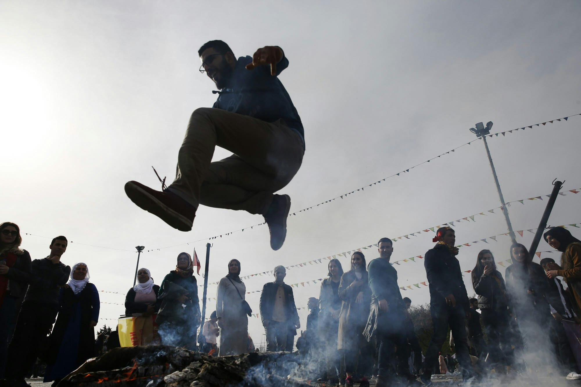 Ein Mann springt über ein Freudenfeuer während der zentralen Feier zum kurdischen Neujahrsfest Newroz.