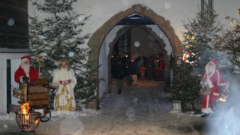 Nikolaus und Weihnachtsengel stehen vor dem Burgeingang zum Burgort Kronenburg.