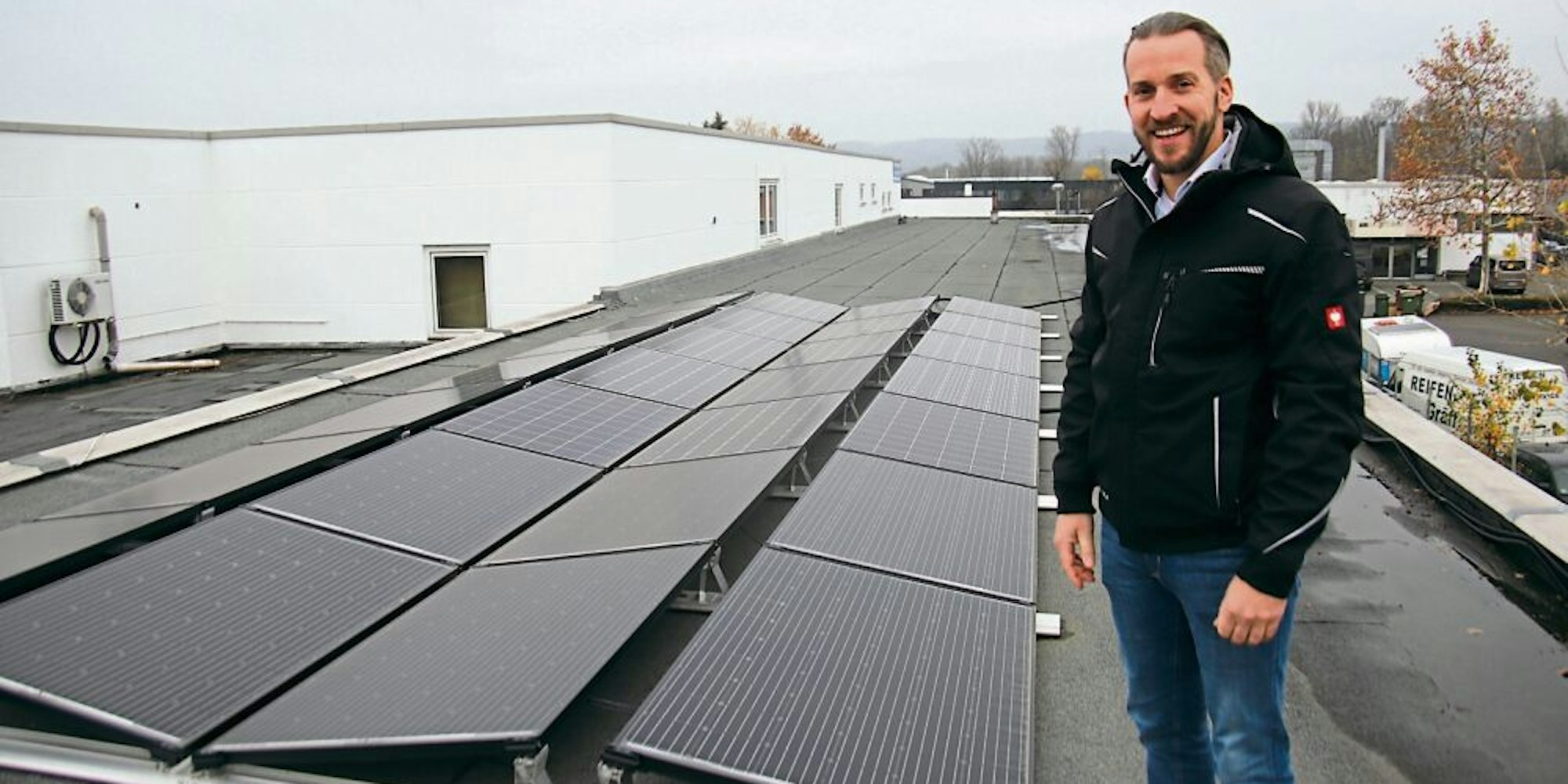 Markus Bolle zeigt auf dem Dach des Firmengebäudes Photovoltaik-Module, die den Strom liefern, einige laufen zu Testzwecken.