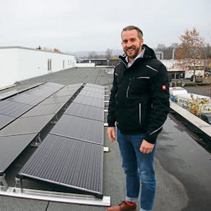 Markus Bolle zeigt auf dem Dach des Firmengebäudes Photovoltaik-Module, die den Strom liefern, einige laufen zu Testzwecken.