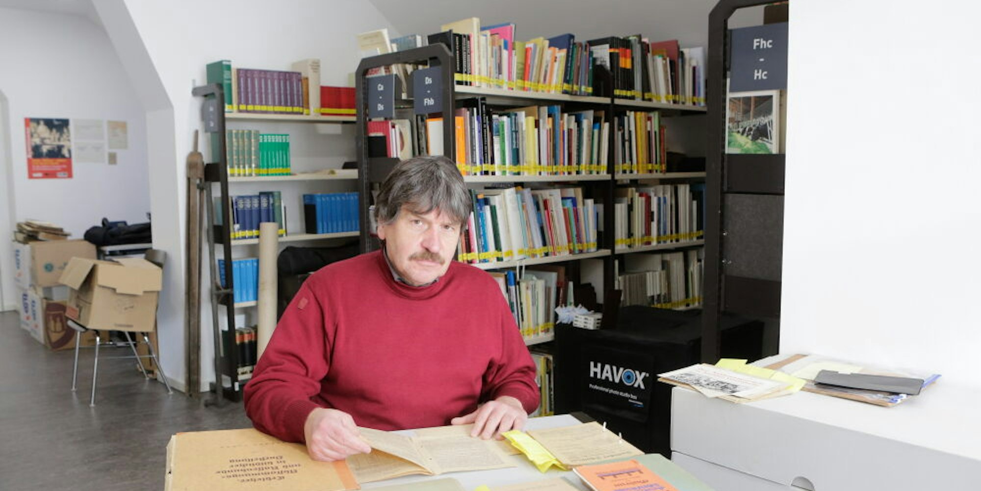 Der Leiter des Freilichtmuseums, Michael Kamp mit NS-Schrifttum aus der ehemaligen Thierer Schulbücherei.