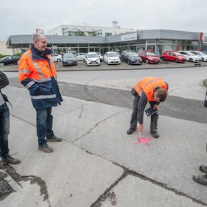 Verkehrsplaner Andreas Schönfeld, Projektleiter Straßenbau Ulrich van Acken und Schachtmeister Wolfgang Berg (v. l.) beobachten, wie der Mittelpunkt des Kreisverkehres festgelegt wird.