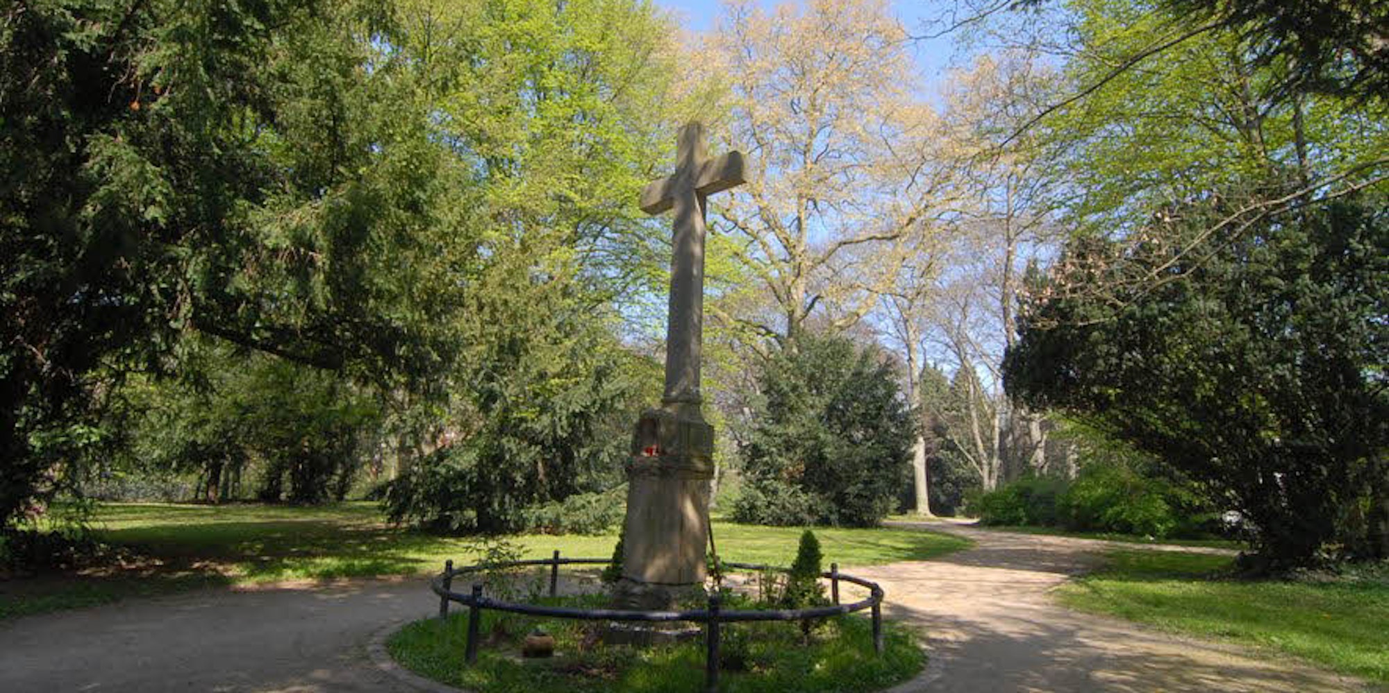 Ein altes Hochkreuz erinnert noch daran, dass die Grünanlage in der Nähe der Feltenstraße einmal ein Friedhof war.