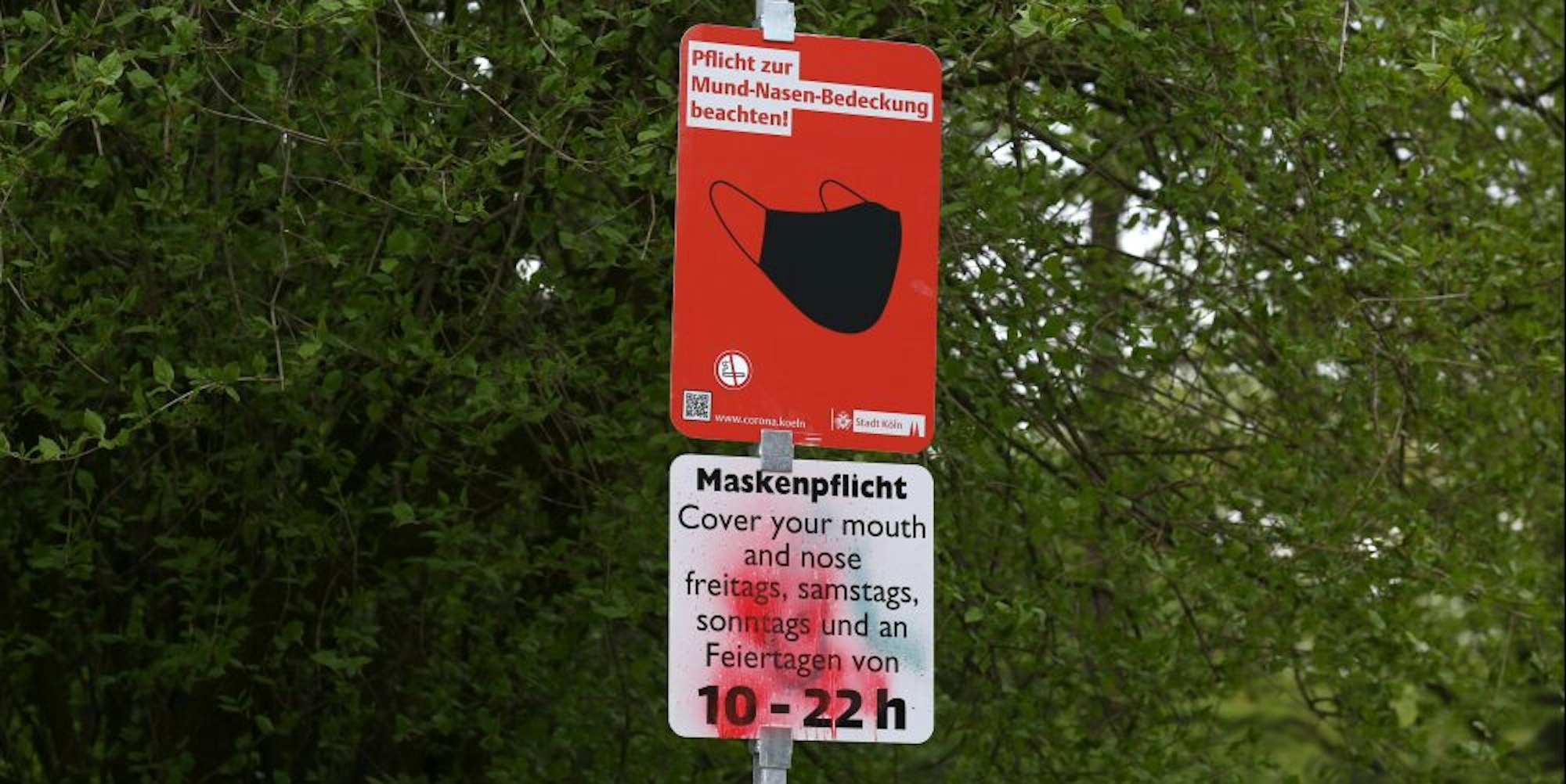 Ein Hinweisschild zur Maskenpflicht an einem Kölner Park.