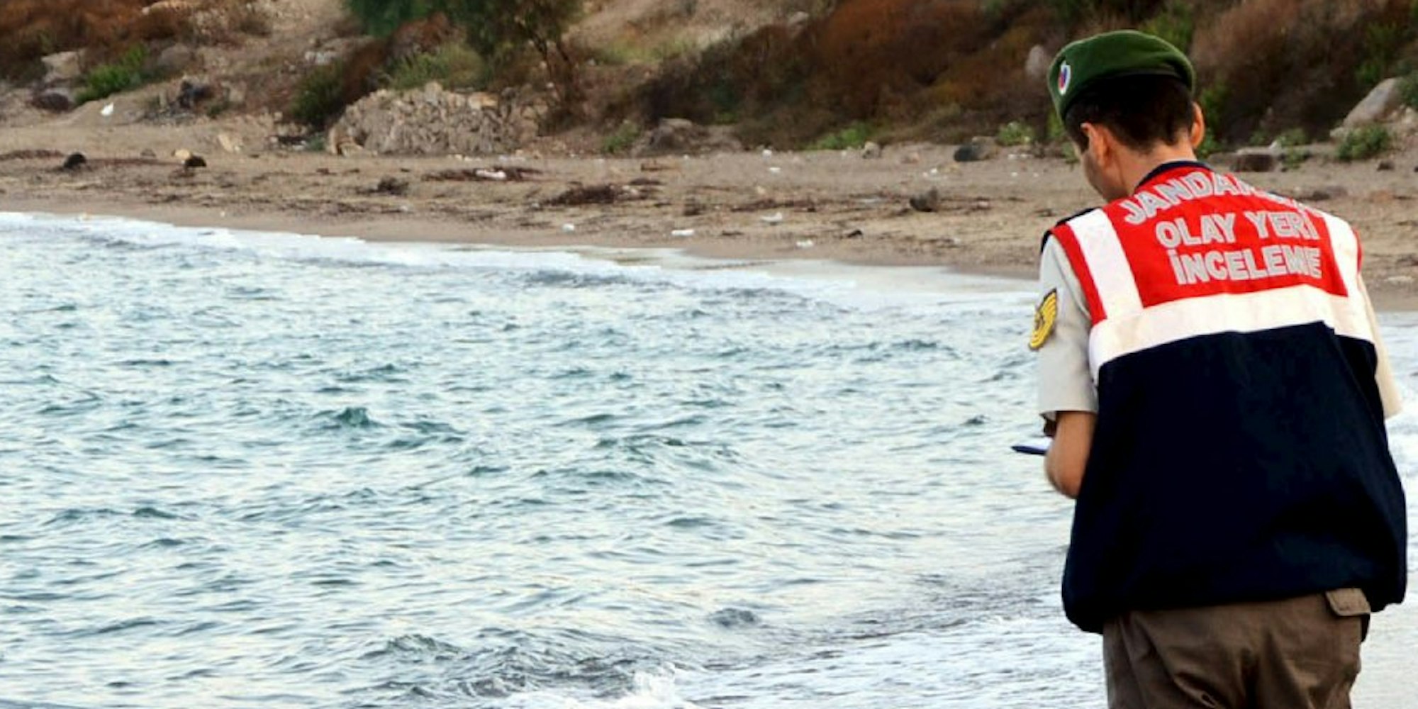 Diesem Polizisten fiel die Aufgabe zu, Aylan Kurdi vom Strand in Bodrum aufzuheben.