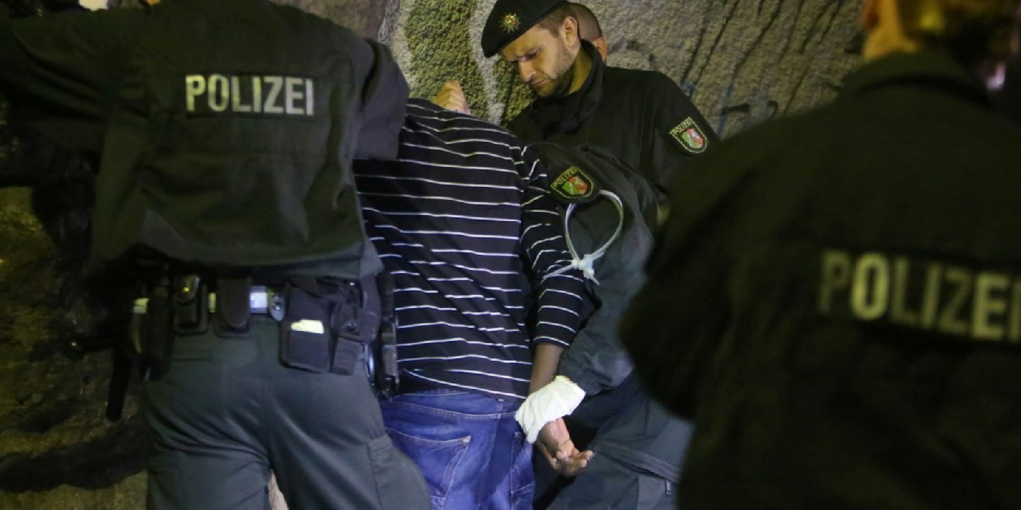 Polizisten nehmen in der Altstadt einen jungen Mann nach einem Taschendiebstahl fest.