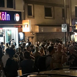 Viele Leute stehen dicht gedrängt vor einem Kiosk und anderen Lokalen an der Zülpicher Straße, Ecke Zülpicher Platz