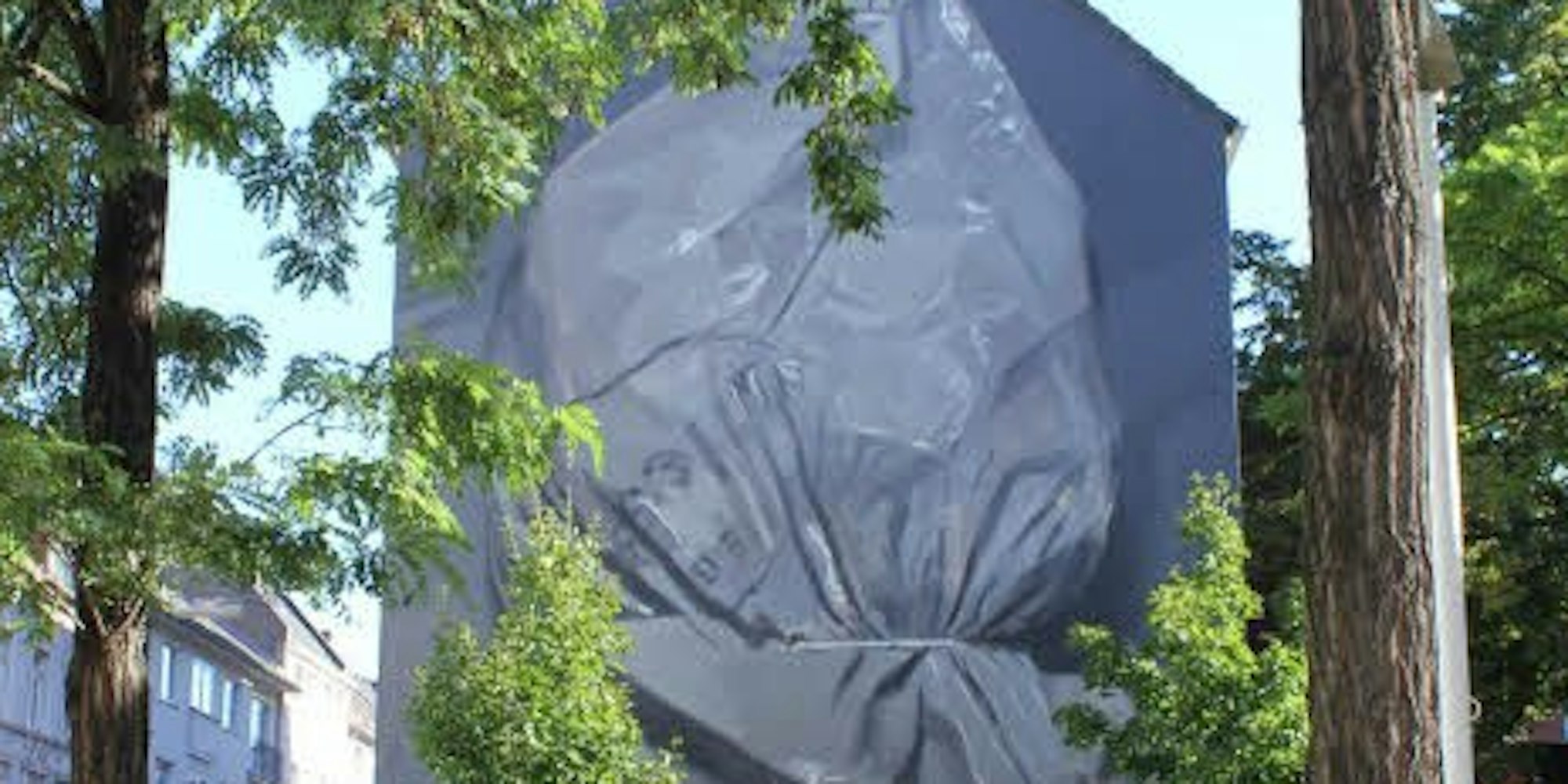 Gegenüber dem Norbert-Burger-Seniorenzentrum zeigt das Wandbild einen männlichen Kopf mit übergestülpter Plastiktüte.