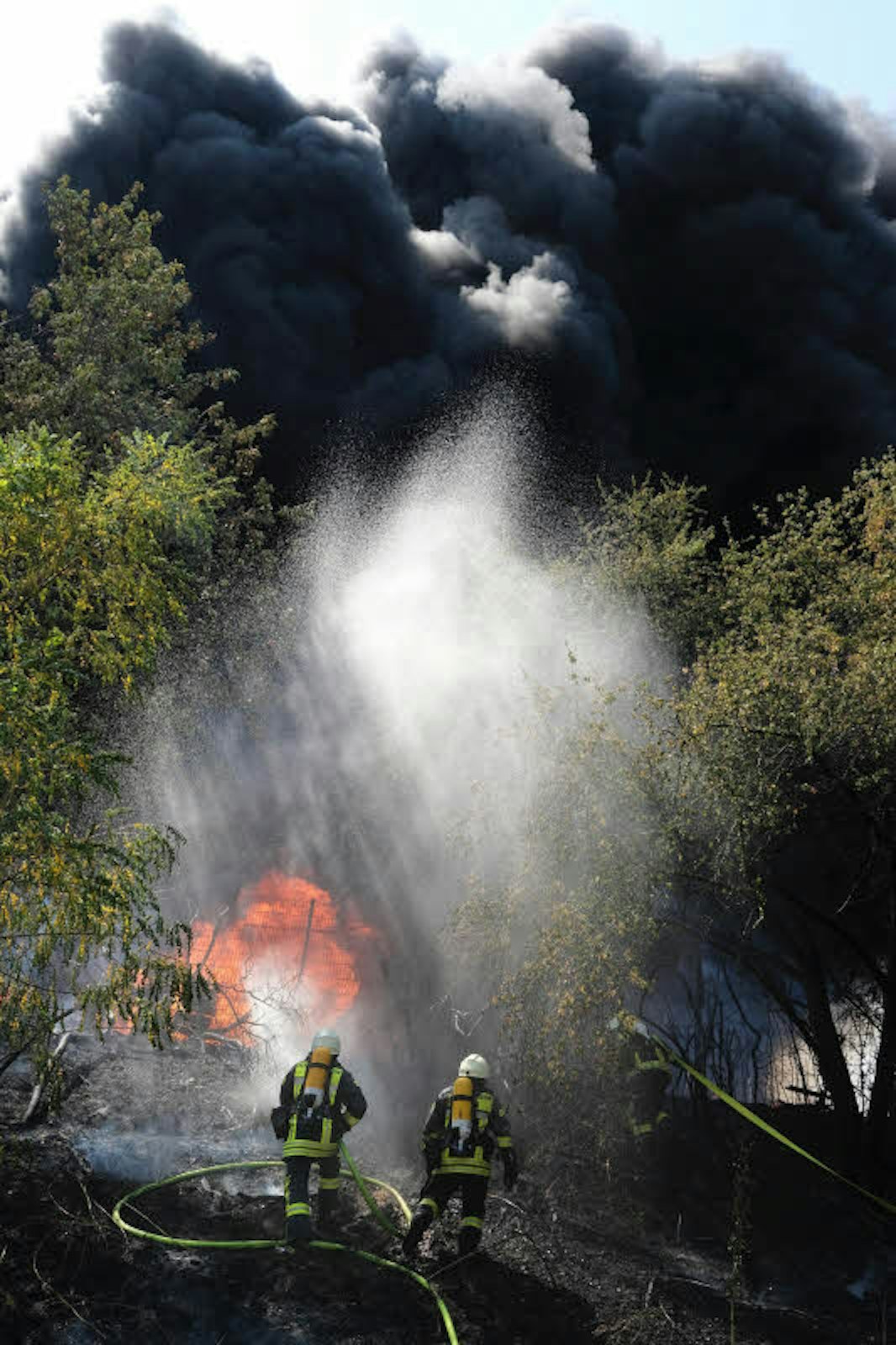 Feuerwehrmänner bekämpfen den Großbrand am Alexianer Krankenhaus in Porz-Ensen.