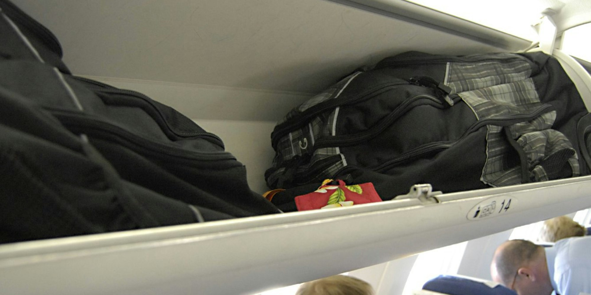 Damit das Handgepäck im Flugzeug nicht den Mittelgang versperrt, muss es sicher verstaut werden.