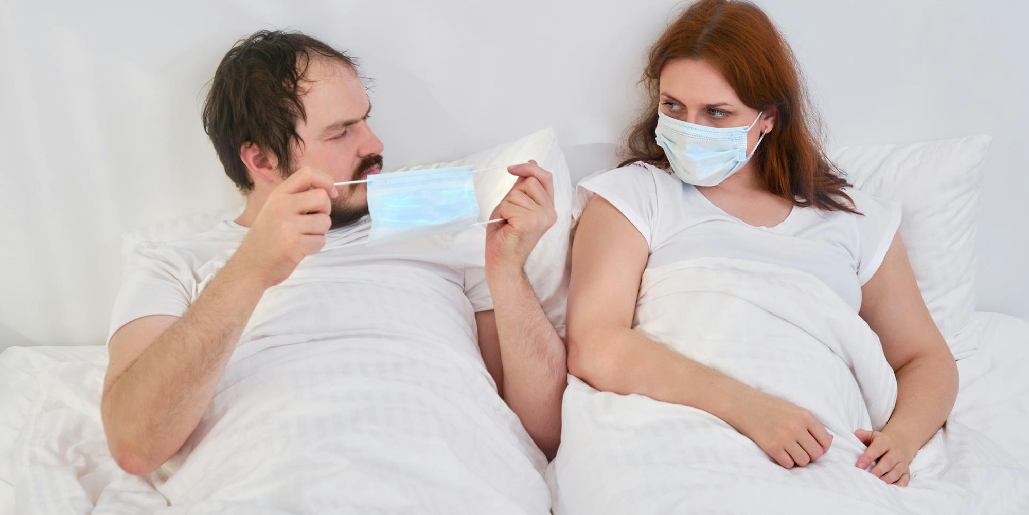 Paar mit Masken im Bett Getty Images