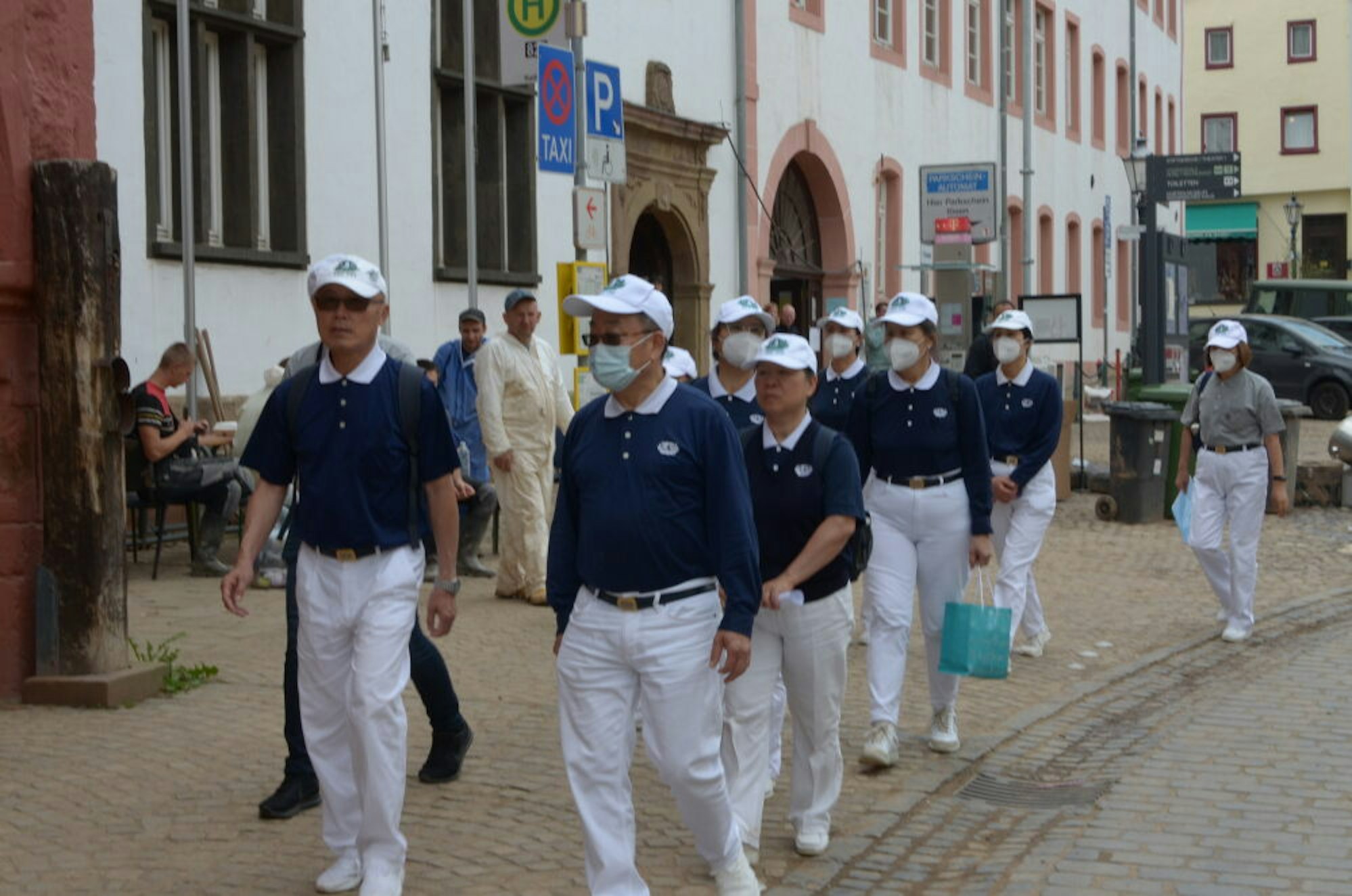 Mitglieder des taiwanischen Vereins Tzu Chi, der Flutopfern helfen will, auf ihrem Weg ins Münstereifeler Rathaus.