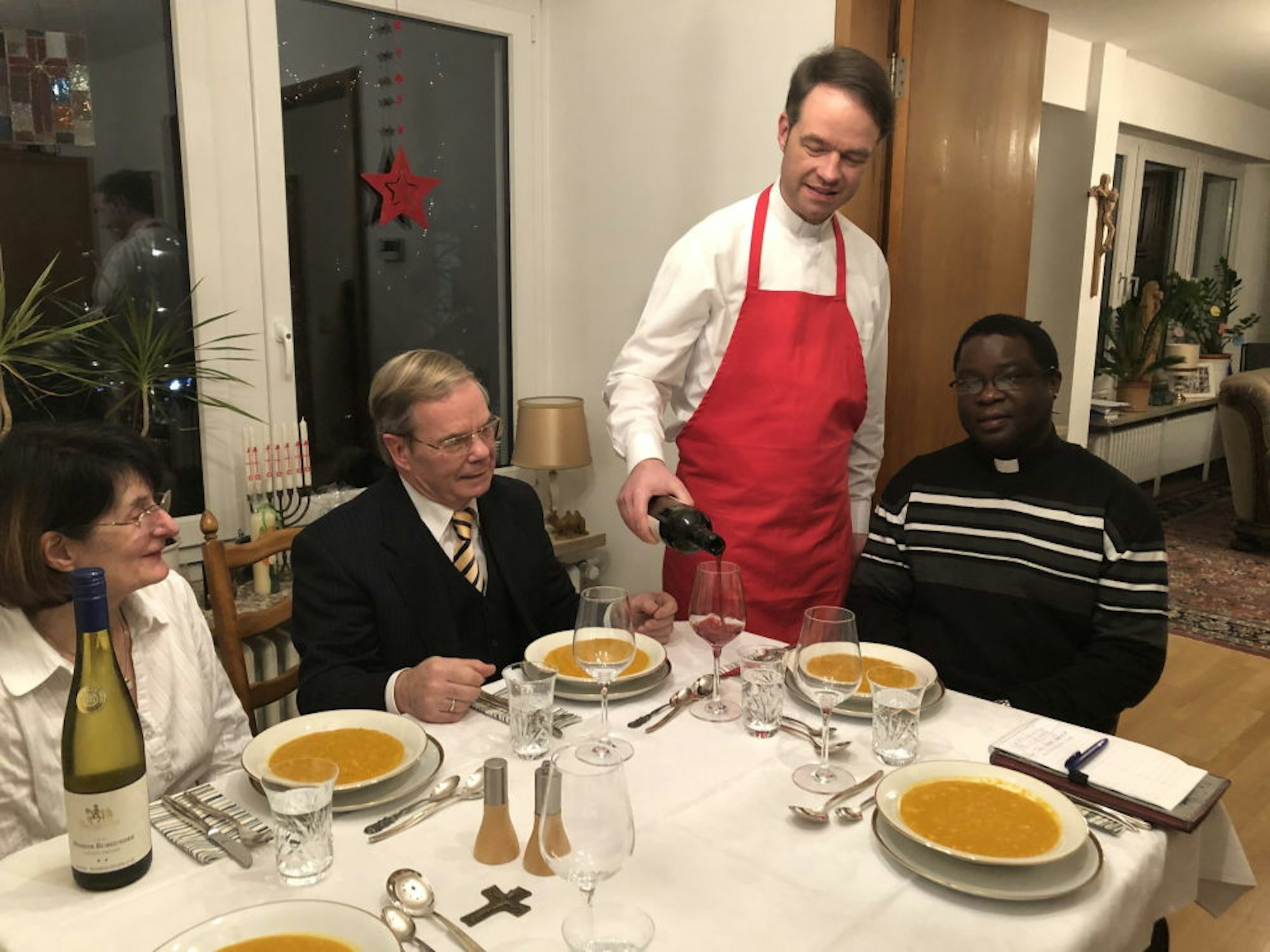 Zum Essen mit seinen Eltern Marlies und Herbert sowie Pfarrer Cédric Kongbo-Gbassinga kredenzt Andreas Süß badischen Wein.