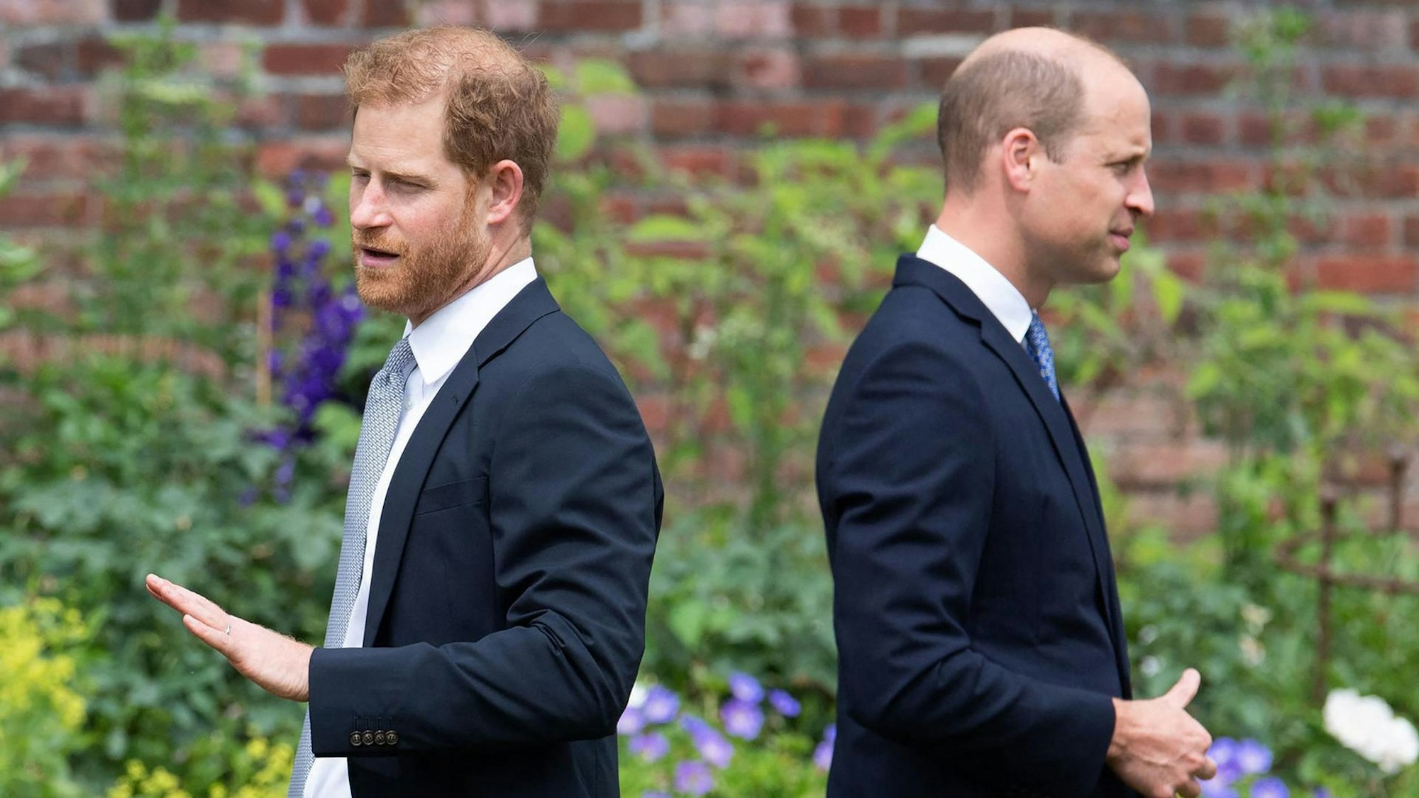Prinz Harry und Prinz William stehen mit dem Rücken zueinander.