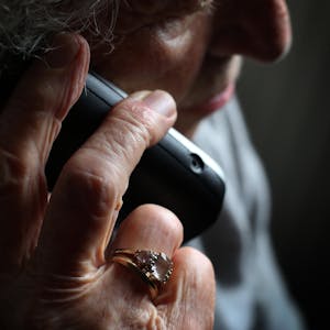 Ältere Frau mit Telefon in der Hand.