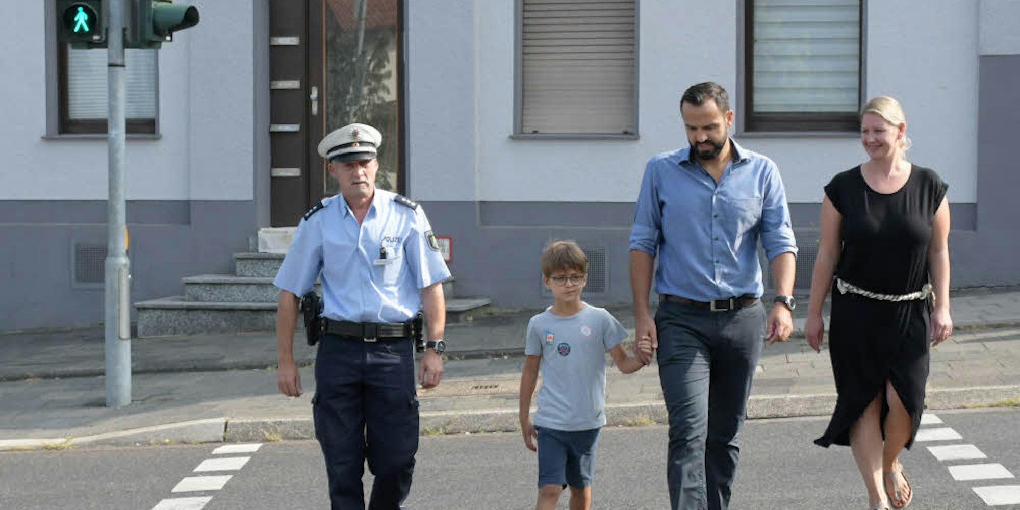 Polizist Manfred Wrana, der sechsjährige Daron und seine Eltern üben das richtige Verhalten an der Ampel.