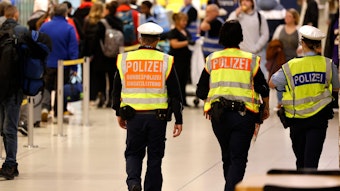 Bundepolizisten gehen durch die Flughafenhalle.