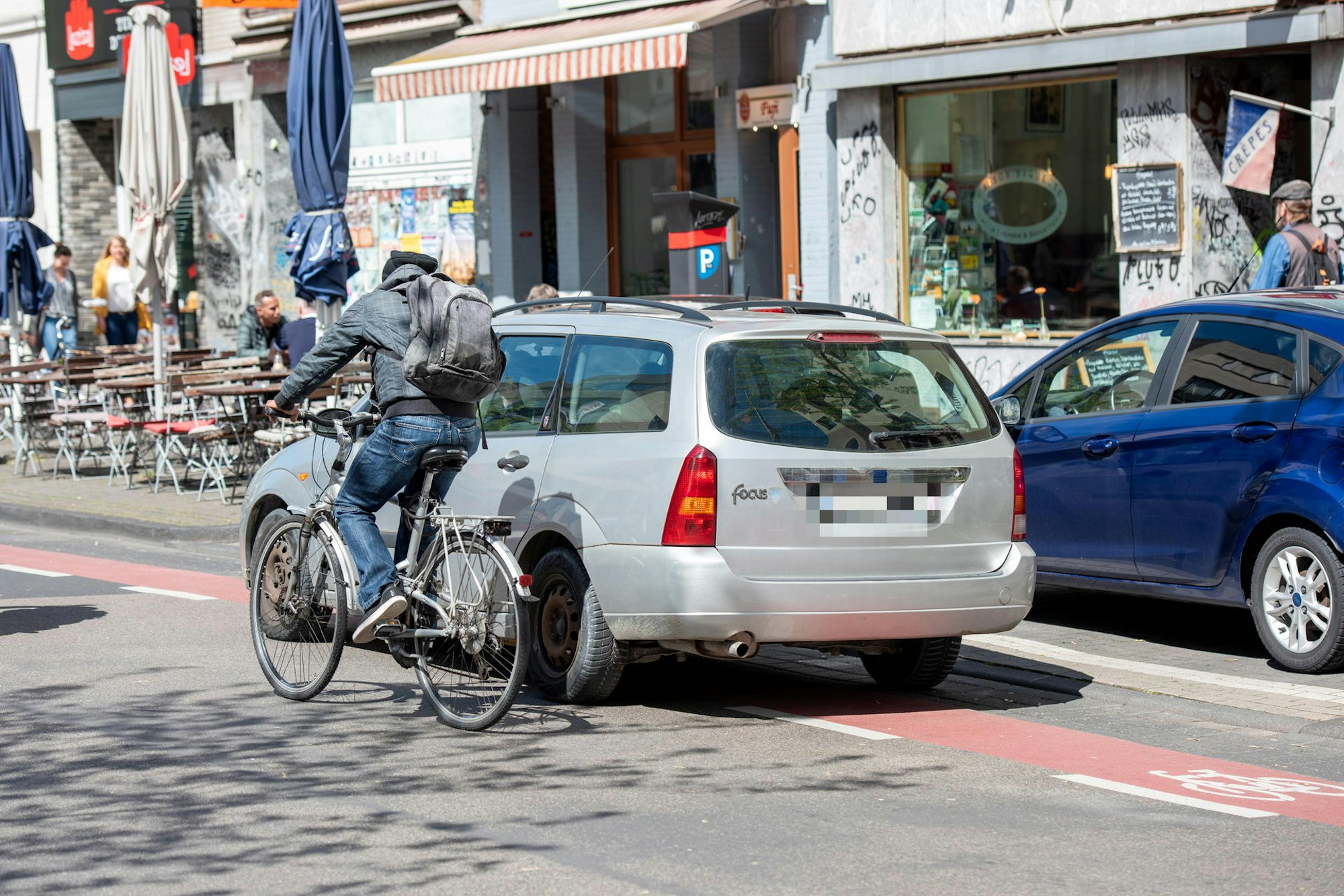 Ein Autofahrer blockiert auf der Venloer Straße den rot markierten Radfahrstreifen.