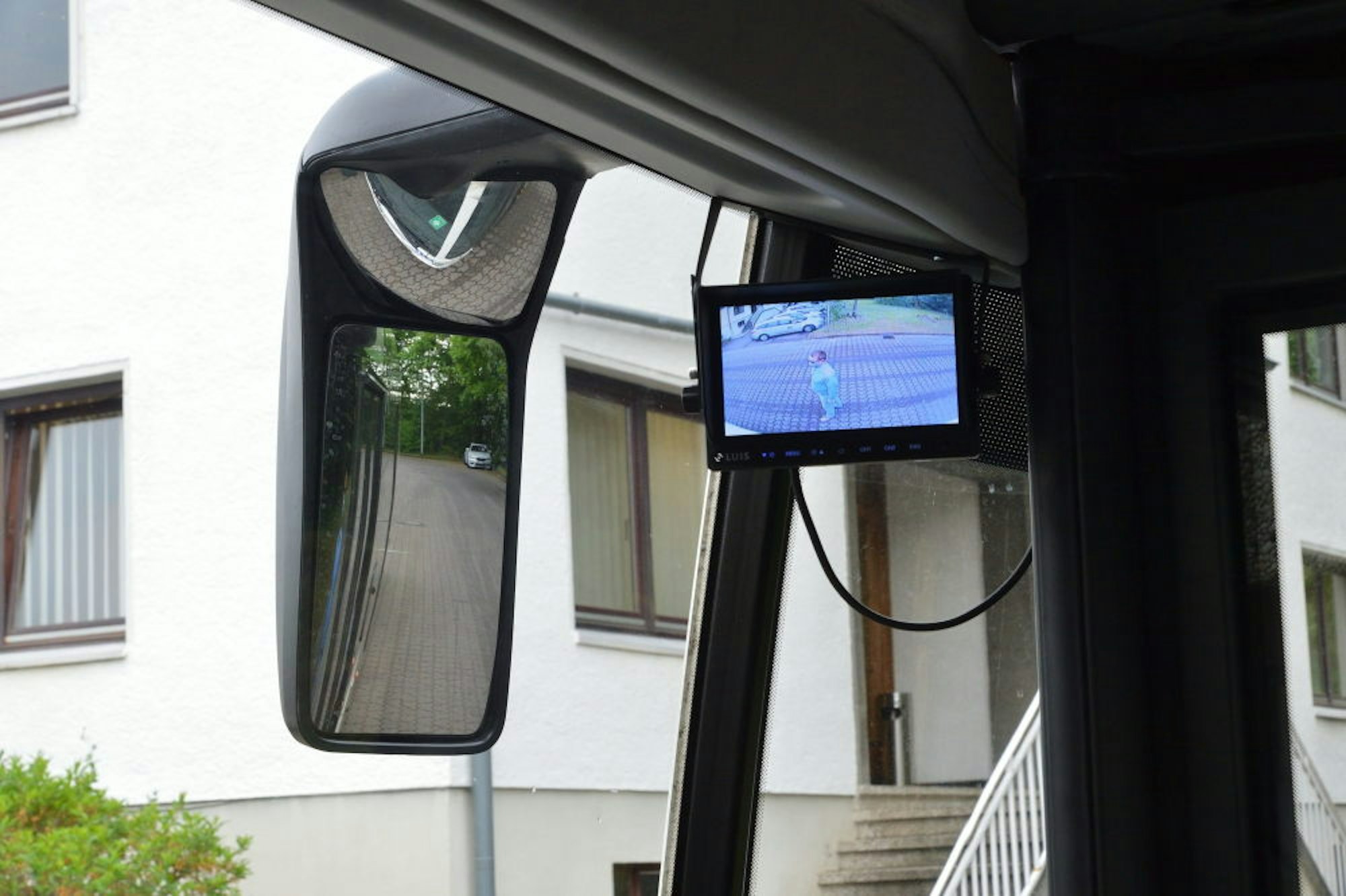 Auf dem Bildschirm des Abbiegeassistenten (rechts) sieht der Busfahrer den Menschen im Toten Winkel, den seine Spiegel (links) nicht abdecken.