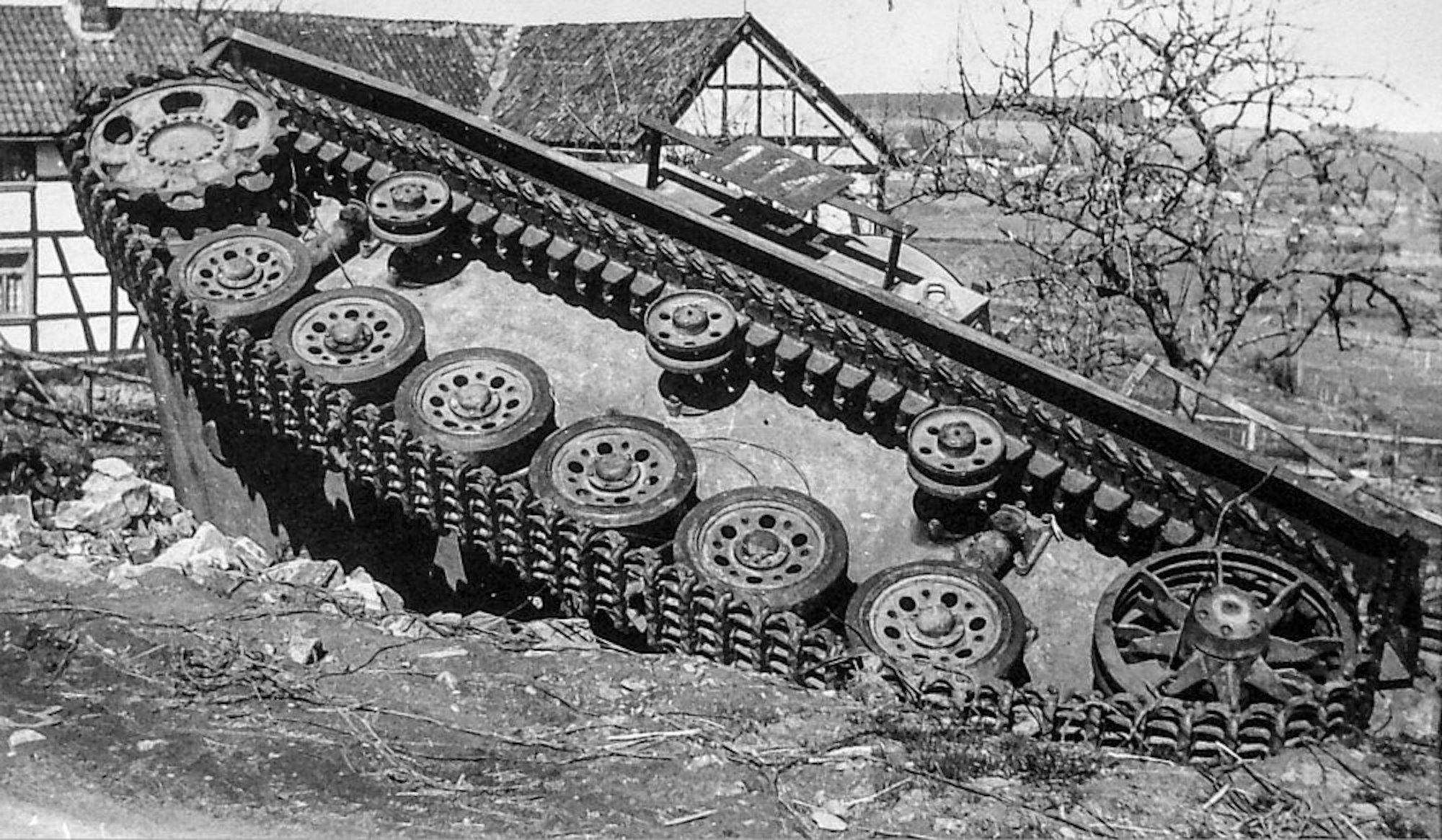 Ein zerstörter Panzer der Wehrmacht liegt an einer Straße in der Eifel: Die Kriegswucht war wenige Tage nach Beginn der Offensive sichtbar.