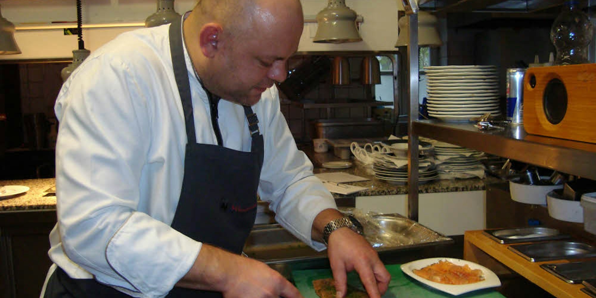 Mit einem scharfen Messer trennt der Koch Sven Messerschmidt den gebeizten Lachs von der Haut.
