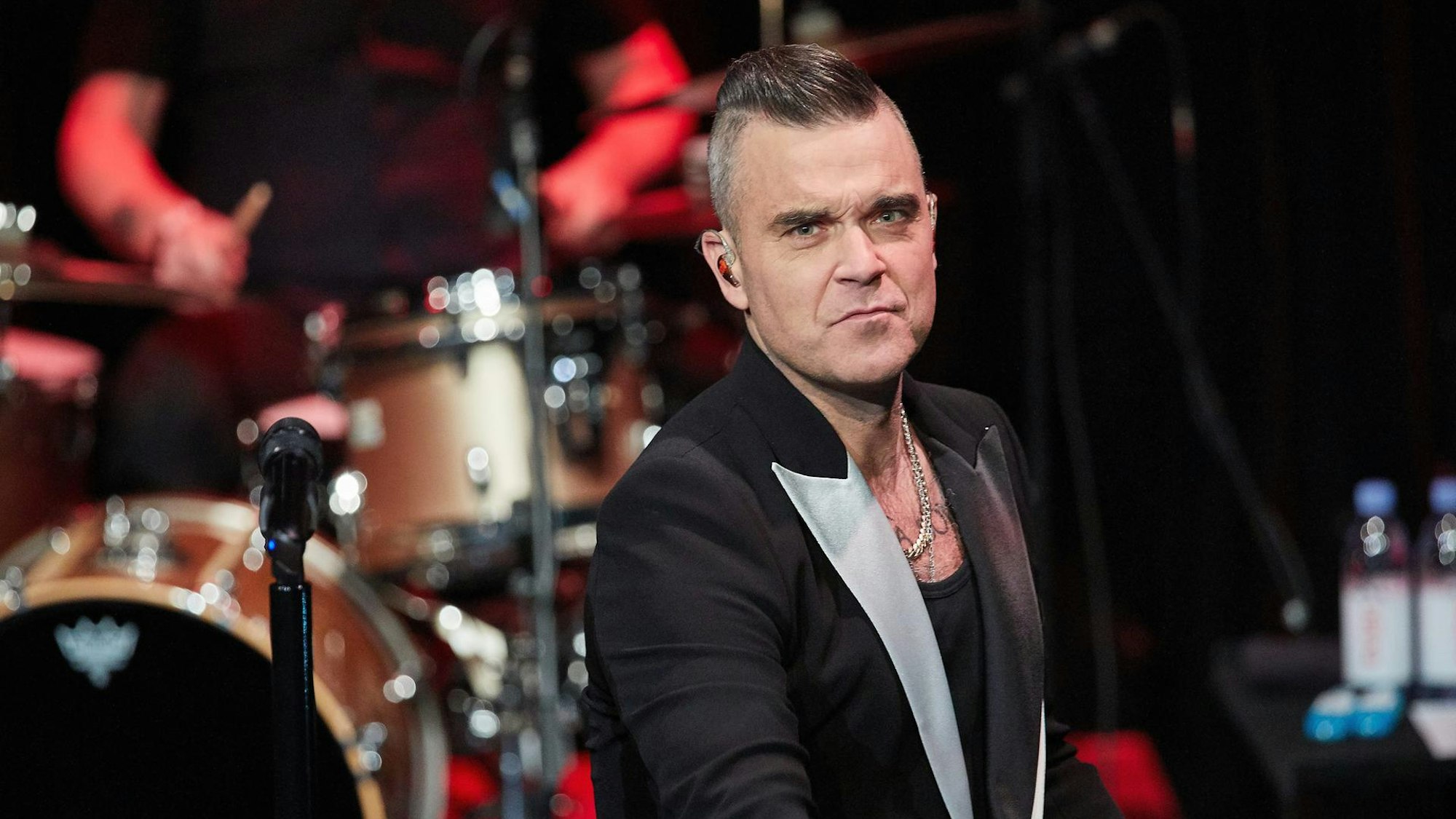 Robbie Williams bei einem Konzert auf der Bühne.