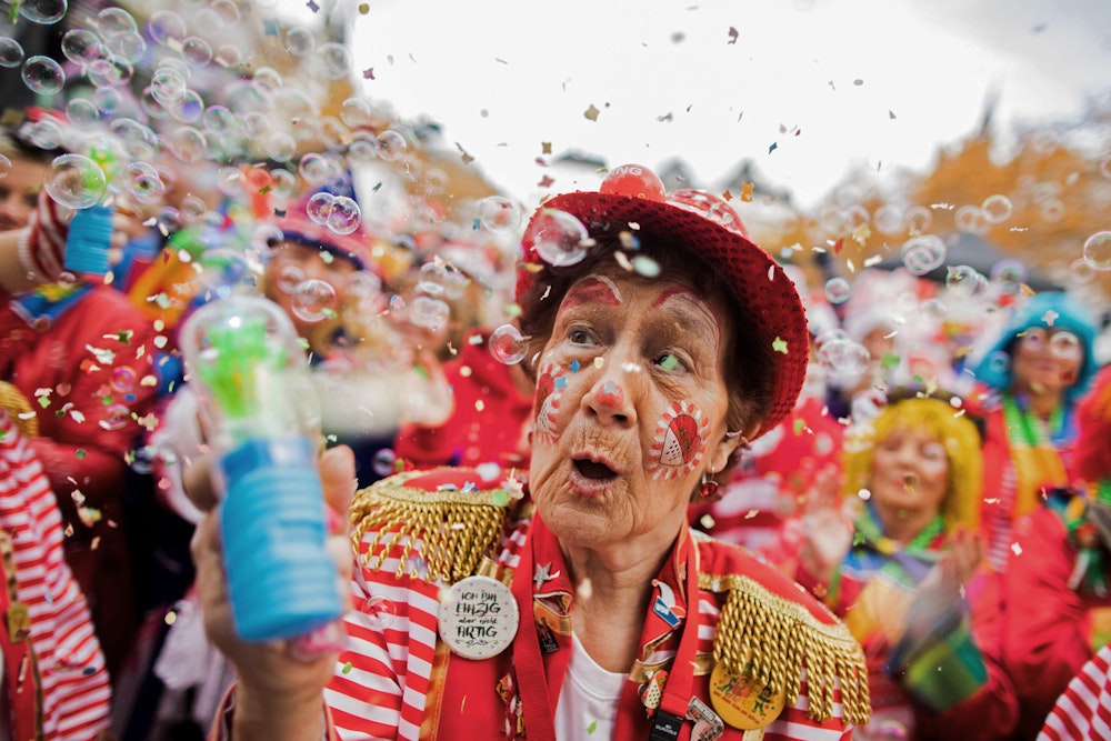 Eine Karnevalistin versprüht in Köln Seifenblasen.
