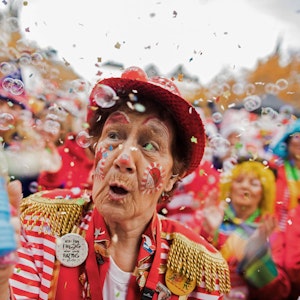 Eine Karnevalistin versprüht in Köln Seifenblasen.
