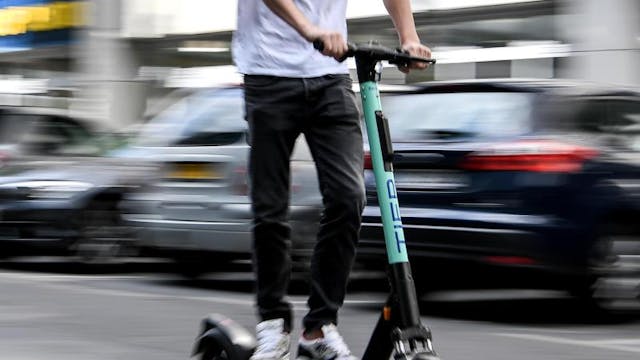 Ein Mann fährt mit einem E-Tretroller auf der Straße. (Symbolbild)