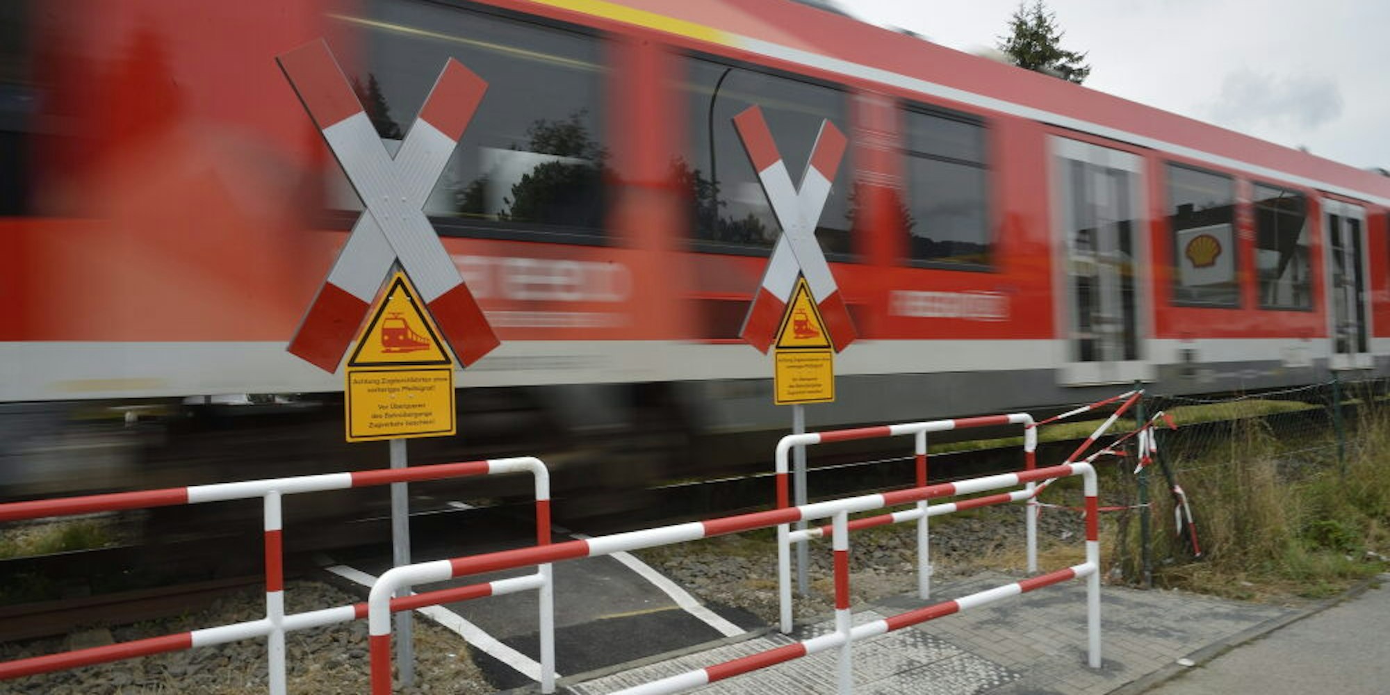Auf gelben Schildern wird gewarnt: „Achtung Zugdurchfahrten ohne vorheriges Pfeifsignal!“
