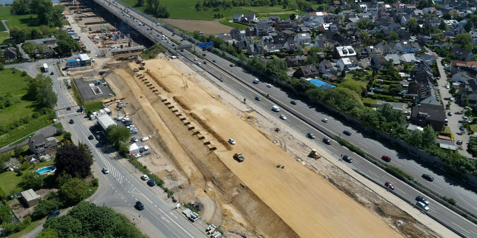 Parallel zur Autobahn A1 laufen die Arbeiten für den Neubau der Brücke, die Kampfmittelsuche im Rhein aber verzögern sich.