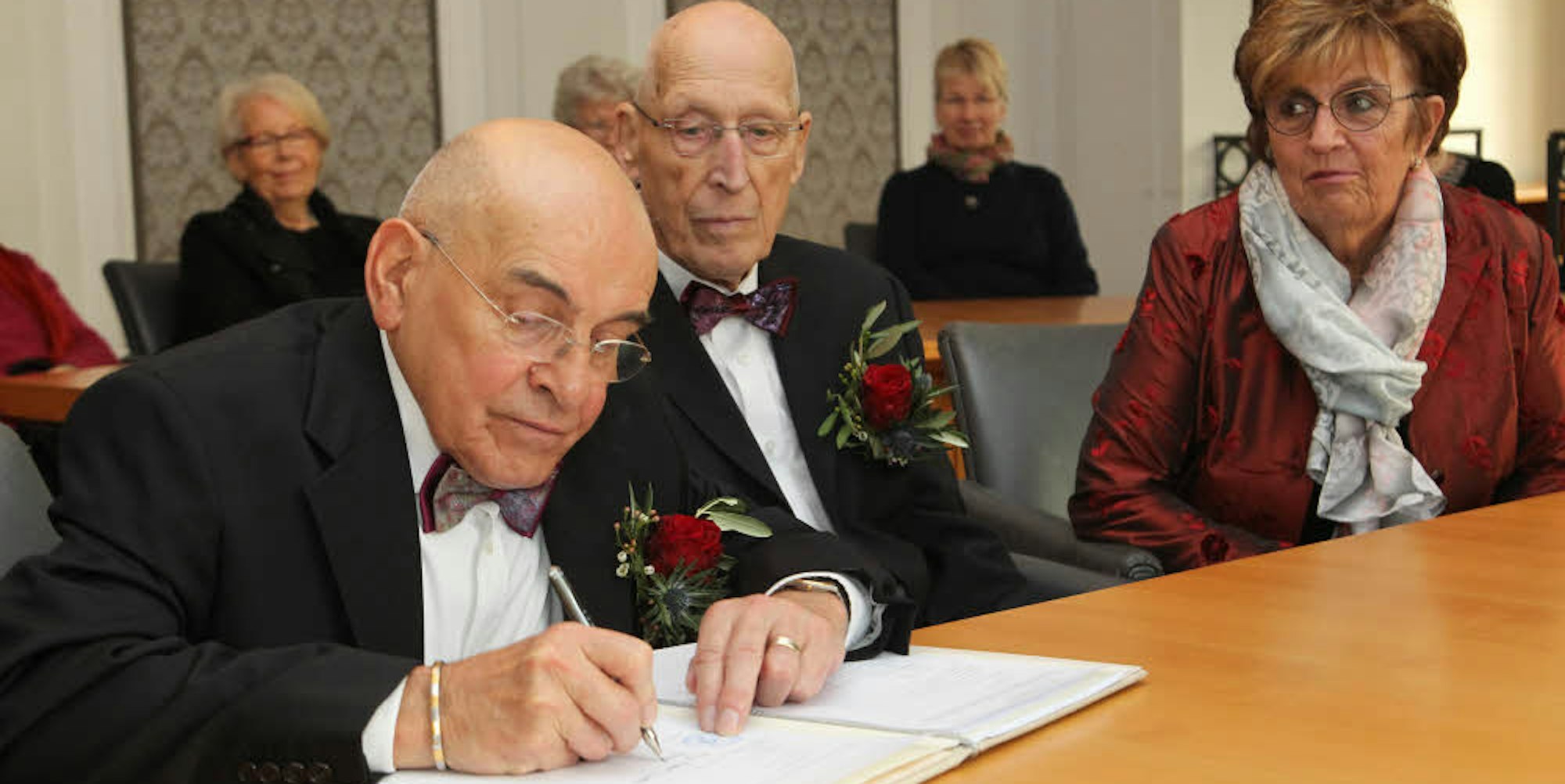 Im Hennefer Standesamt unterschreiben Herbert Dellory (links) und Michael Wloka die Heiratsurkunde. Ihre Freundschaftsringe, die sie 1972 tauschten, dienen nun als Eheringe.