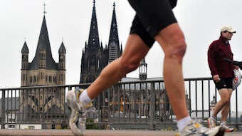Ein Läufer auf der Deutzer Brücke, im Hintergrund der Kölner Dom.