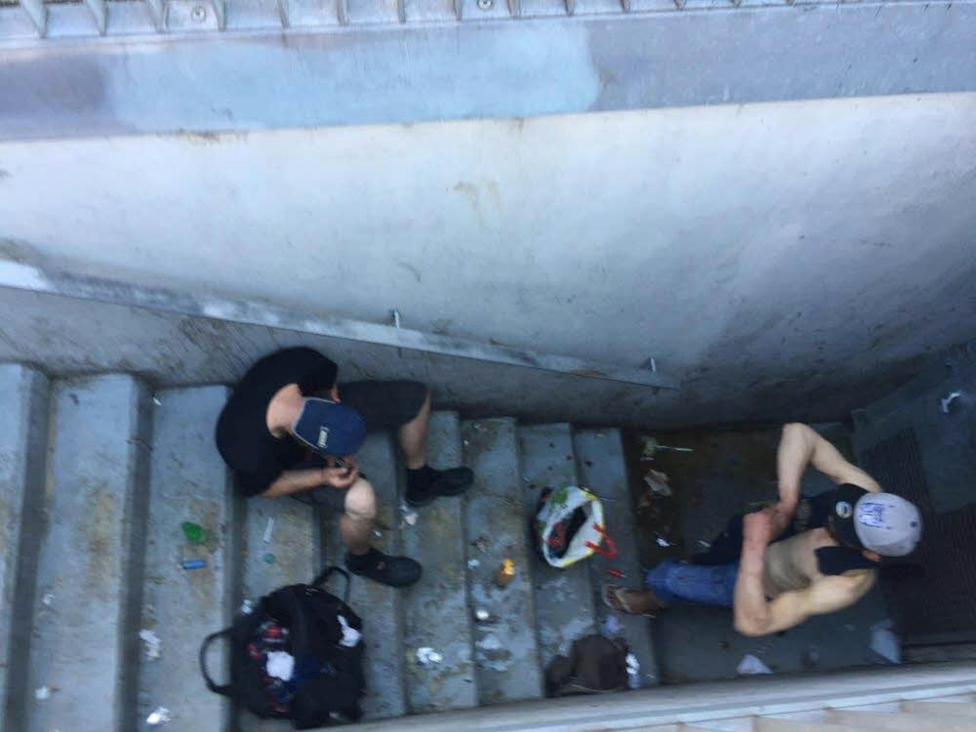 Zwei Männer auf einem Treppenabgang auf dem Neumarkt, einer setzt sich einen Schuss Heroin.