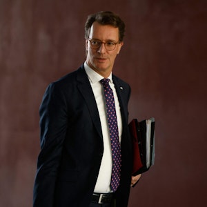 NRW-Ministerpräsident Hendrik Wüst trägt eine Aktenmappe.