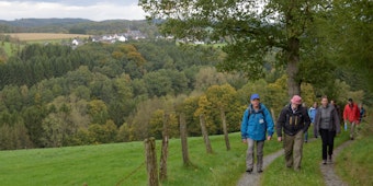 Eine Wanderung mit Winfried Panske (l.). Im Hintergrund ist das Kirchdorf Linde mit St. Josef zu sehen.
