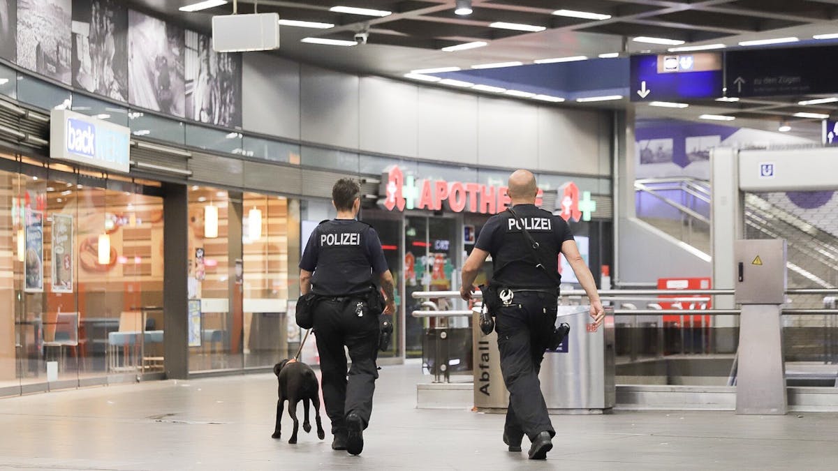 Polizisten laufen mit einem Diensthund durch den Hauptbahnhof Gelsenkirchen.