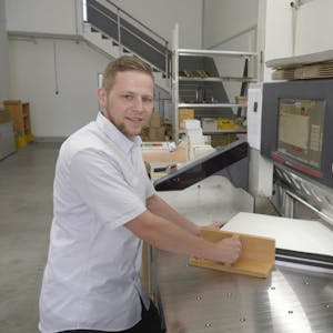 Jungunternehmer Nico Braun in seiner neuen Firma an einer Maschinen zum Schneiden und Falzen.